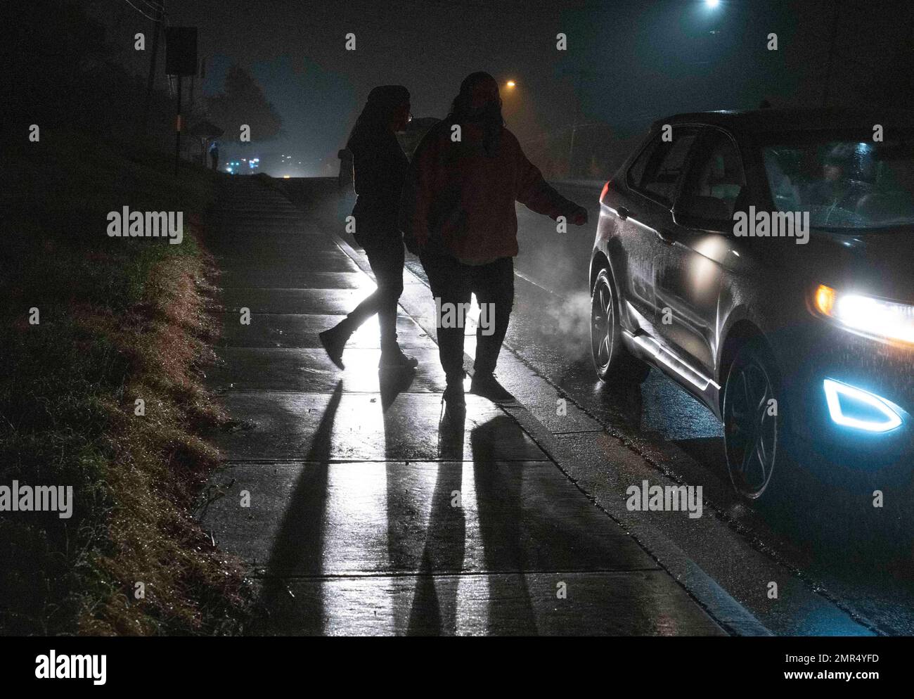 Austin Texas USA, January 28 2023: Volunteers walk towards car on cold, wet night after looking in vacant lots for homeless people sheltering there overnight. The Ending Community Homelessness Coalition (ECHO) organized the Point-in-Time count, held for the first time since 2020 due to the COVID-19 pandemic. The PIT count helps federal, state and local governments allocate dollars to fight homelessness where there's the most need. ©Bob Daemmrich Stock Photo