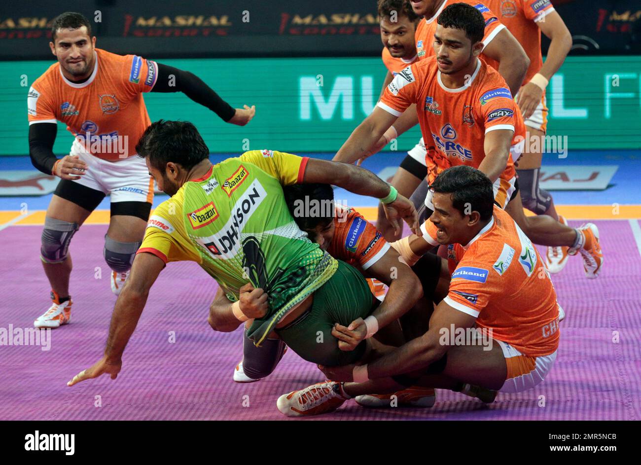 Players of Puneri Paltan pin down Monu Goyat, in green jersey, of Patna  Pirates during their Vivo Pro Kabaddi league match in Mumbai, India,  Tuesday, Oct. 24, 2017. (AP Photo/Rafiq Maqbool Stock