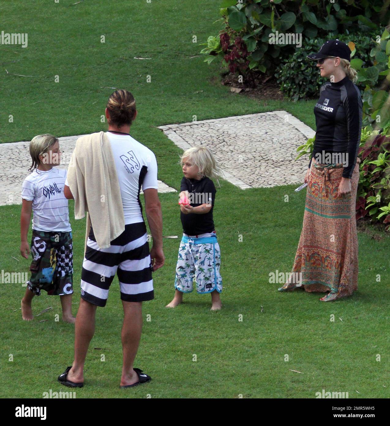 EXCLUSIVE!! Gwen Stefani, husband Gavin Rossdale and the couple's two children Kingston and Zuma spend a fun afternoon playing American Football on the lawn of their luxury hotel. Gavin tried to show Gwen how to throw the ball properly while the boys were more interested in playing in the fountain and filling up their water pistols. Gwen stayed covered up in a surfer's top, baseball cap and sarong and stayed in the shade as much as possible. She was also spotted texting and checking her messages on her iPhone while Gavin played with the kids. The family are spending time together ahead of Gavi Stock Photo