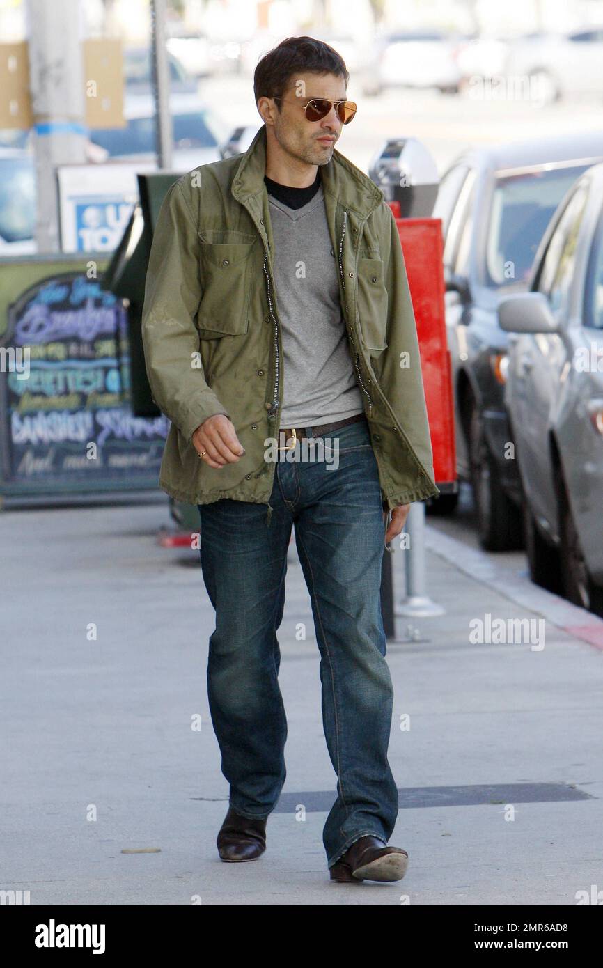 In a nice black ruffled jacket and jeans Halle Berry holds hands with  boyfriend Olivier Martinez, who looked hunky in a casual green jacket, grey  shirt and jeans, as they arrive for