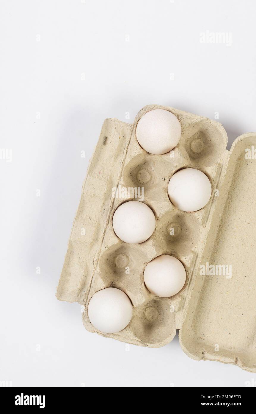 Fresh white chicken eggs in a cardboard tray close-up on white ...