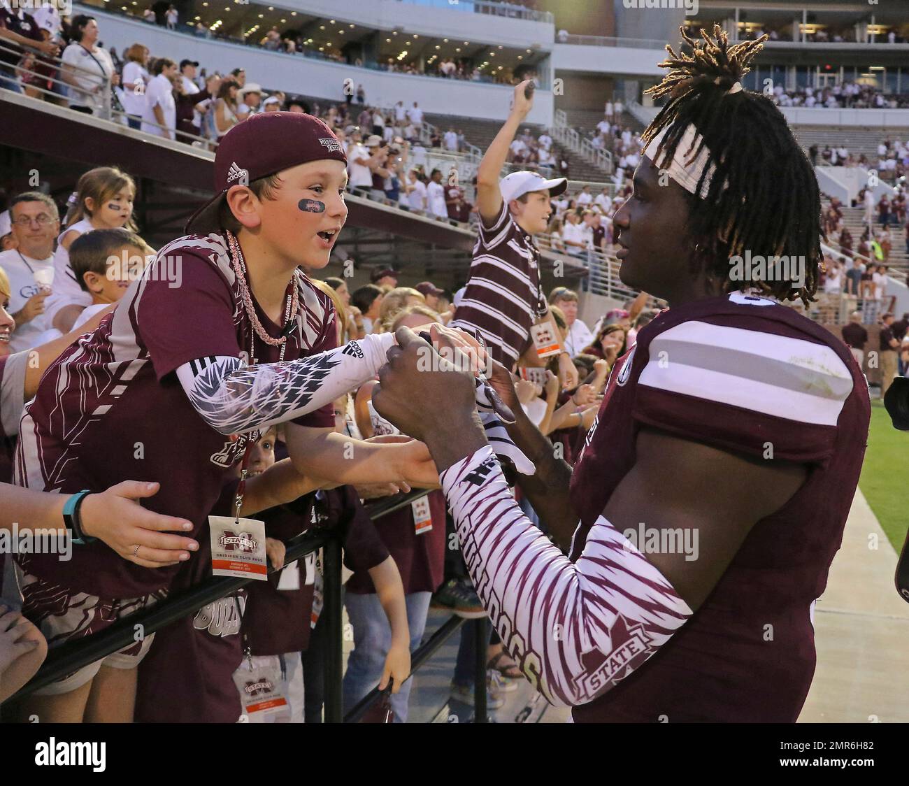 Mississippi State linebacker Willie Gay Jr. (6) hands 9-year-old Trip Lefoe  of Nesbit, Miss his glove after MSU beat Kentucky 45-7 in their NCAA  college football game in Starkville, Miss., Saturday, Oct.