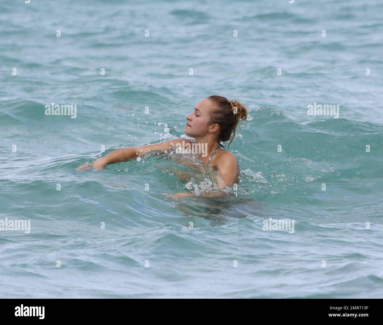 Hayden Panettiere spends Labour Day weekend with friends wearing a colorful bikini and taking a dip in the ocean near her fiancé's beach home. Hayden splashed one over zealous photographer who actually swam up to her in the ocean with his video camera. After drinking a few cocktails and beer, the petite actress swam back along the shore to her condo. Hollywood Beach, FL. 1st September 2013 . Stock Photo