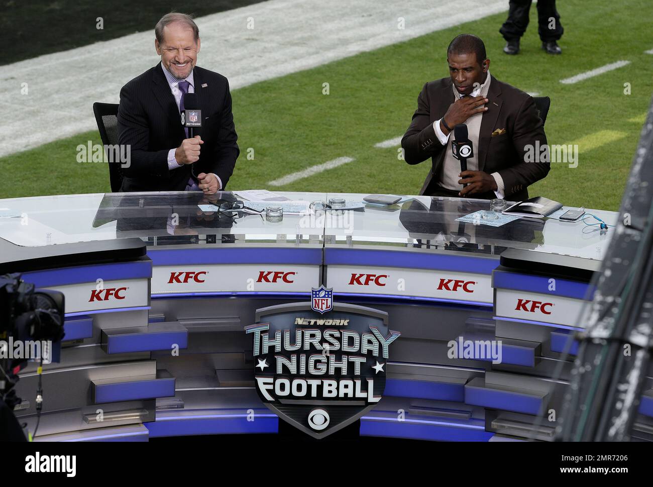 NFL broadcasters Bill Cowher, left, and Deion Sanders talk on set