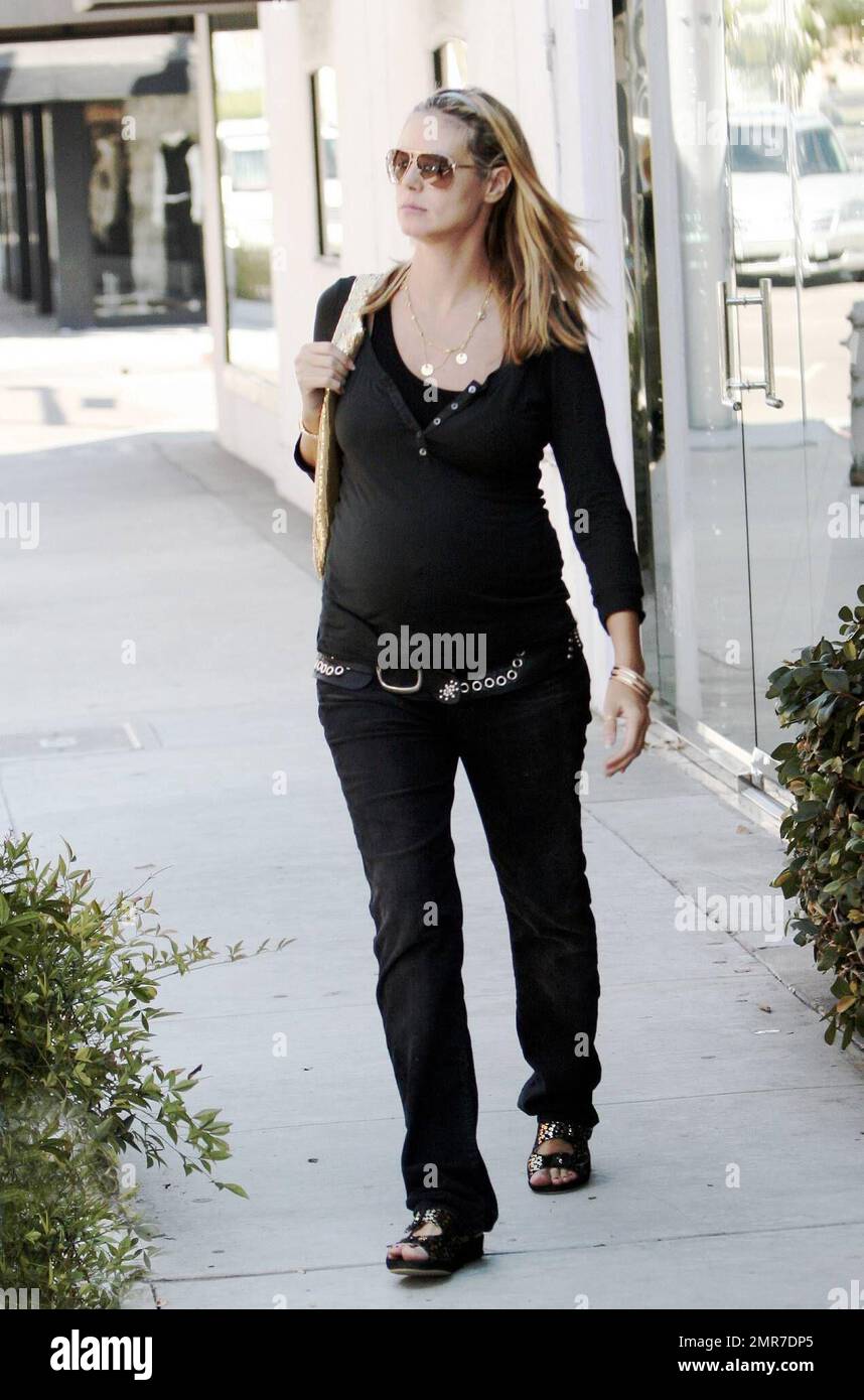 A pregnant Heidi Klum flaunts her bump in a tight fitting top and wears