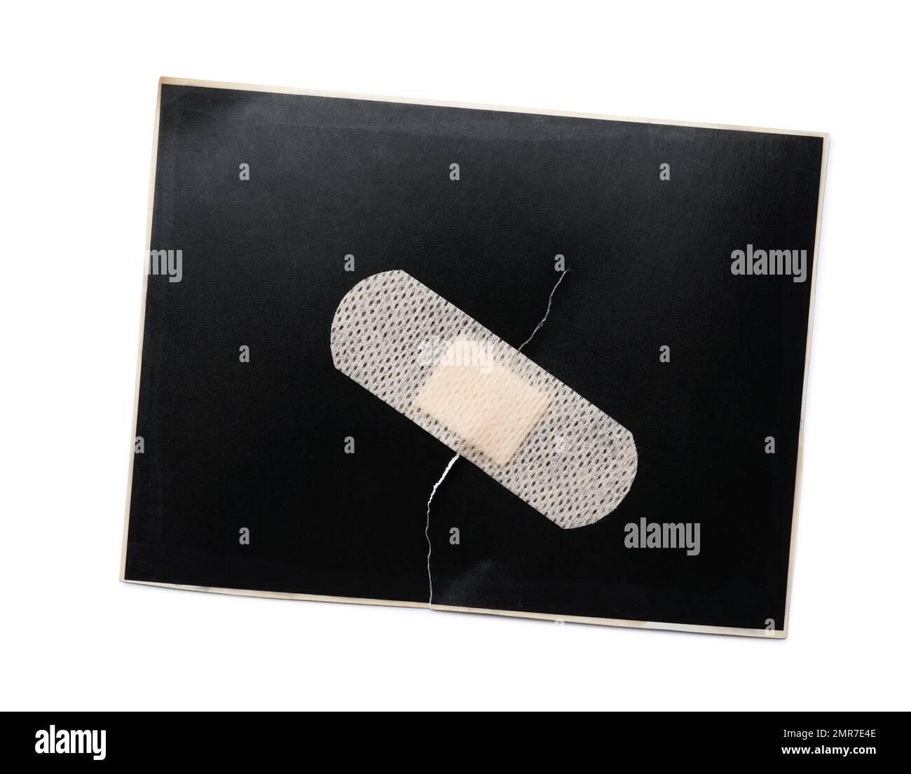 Black paper sheet with sticking plaster isolated on white, top view Stock Photo