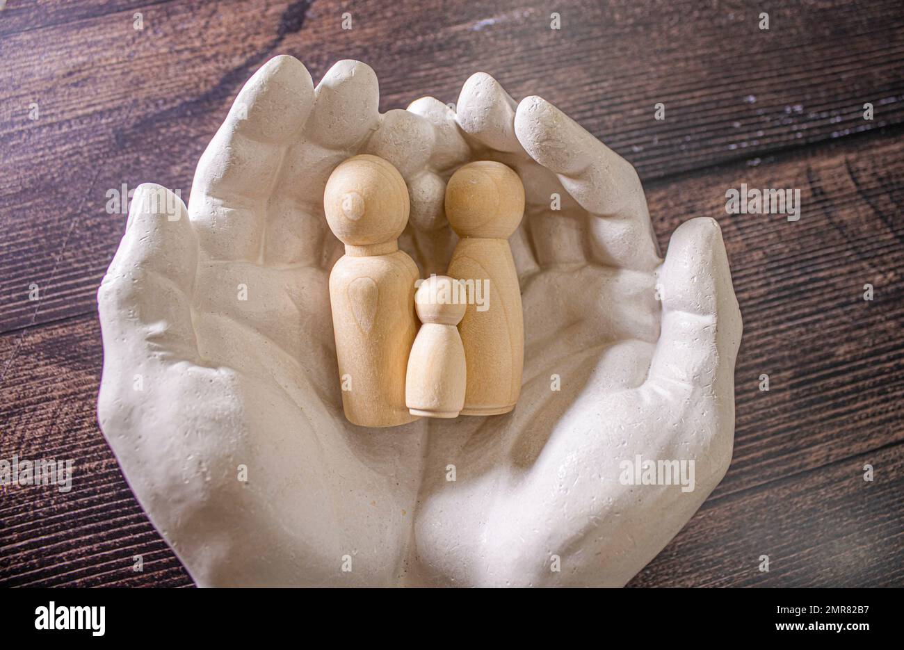 Close up of young women holding people shape male and female doll wooden peg dolls, family day, warmth, happiness, life insurance concept. Stock Photo