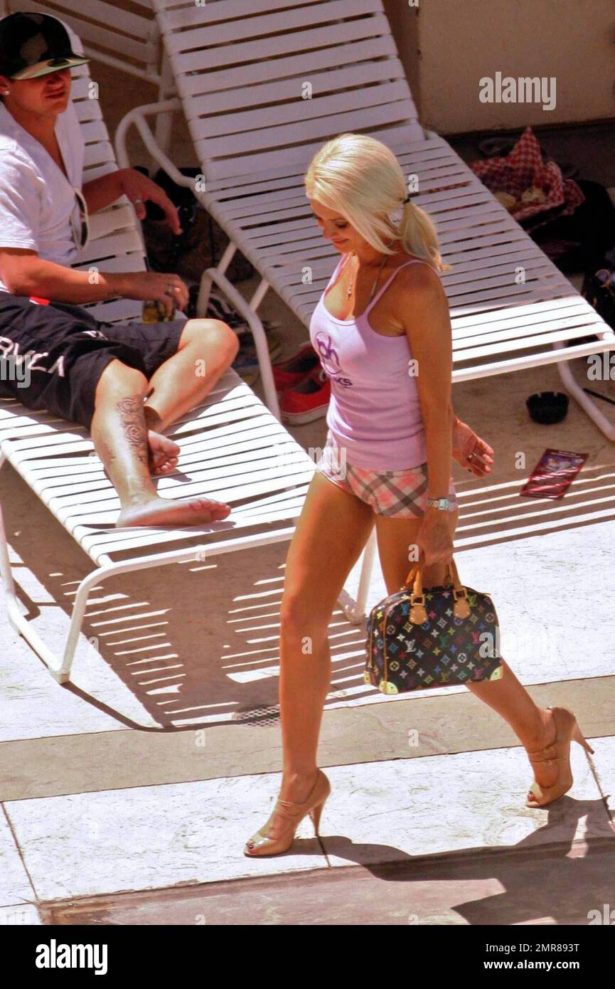 Exclusive!! Holly Madison enjoys some downtime, poolside at her Las Vegas hotel. She enjoyed a cool drink and chatted with fellow pool-goers and even took a moment to examine her belly button while on a break from phone calls. Madison is visiting Las Vegas to attempt the world record bikini parade for the Guinness Book of World Records. Las Vegas, NV. 5/14/09. Stock Photo