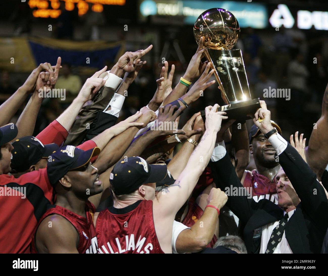 FILE - In this June 20, 2006, file photo, Miami Heat coach Pat Riley, right, helps lift the Larry O'Brien Trophy after beating the Dallas Mavericks in Game 6 of the NBA basketball finals in Dallas. The Miami Heat president has stockpiled nine championship rings, became a best-selling author and motivational speaker, transformed the fashion sense of NBA coaches and left an indelible mark on franchises in Los Angeles, New York and Miami.And he's not done. (AP Photo/Eric Gay, File) Stock Photo