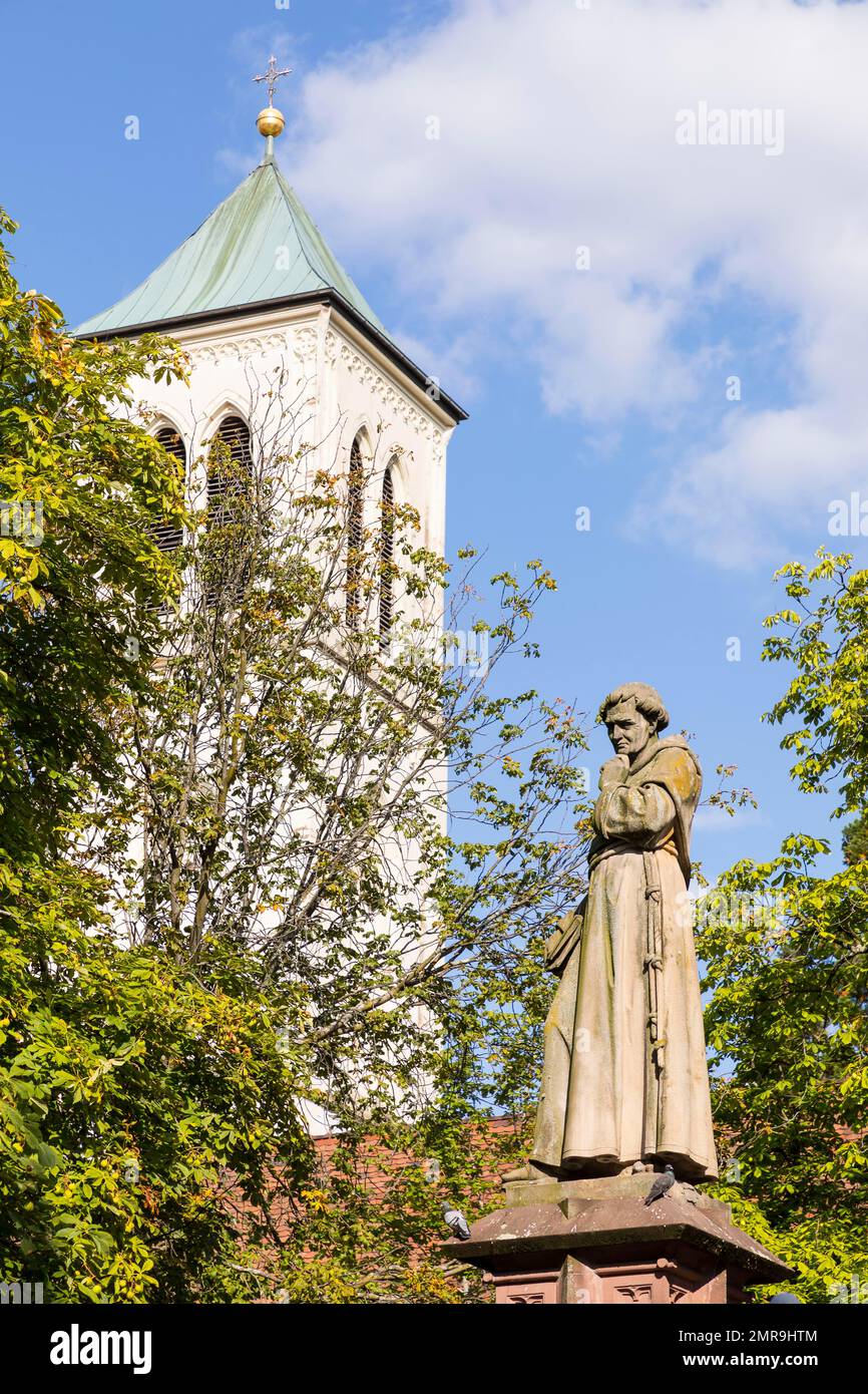 Fountain figure of Monk Berthold Schwarz on the town hall square, in the background the steeple of St. Martin's Church, Freiburg im Breisgau, Baden-Wü Stock Photo