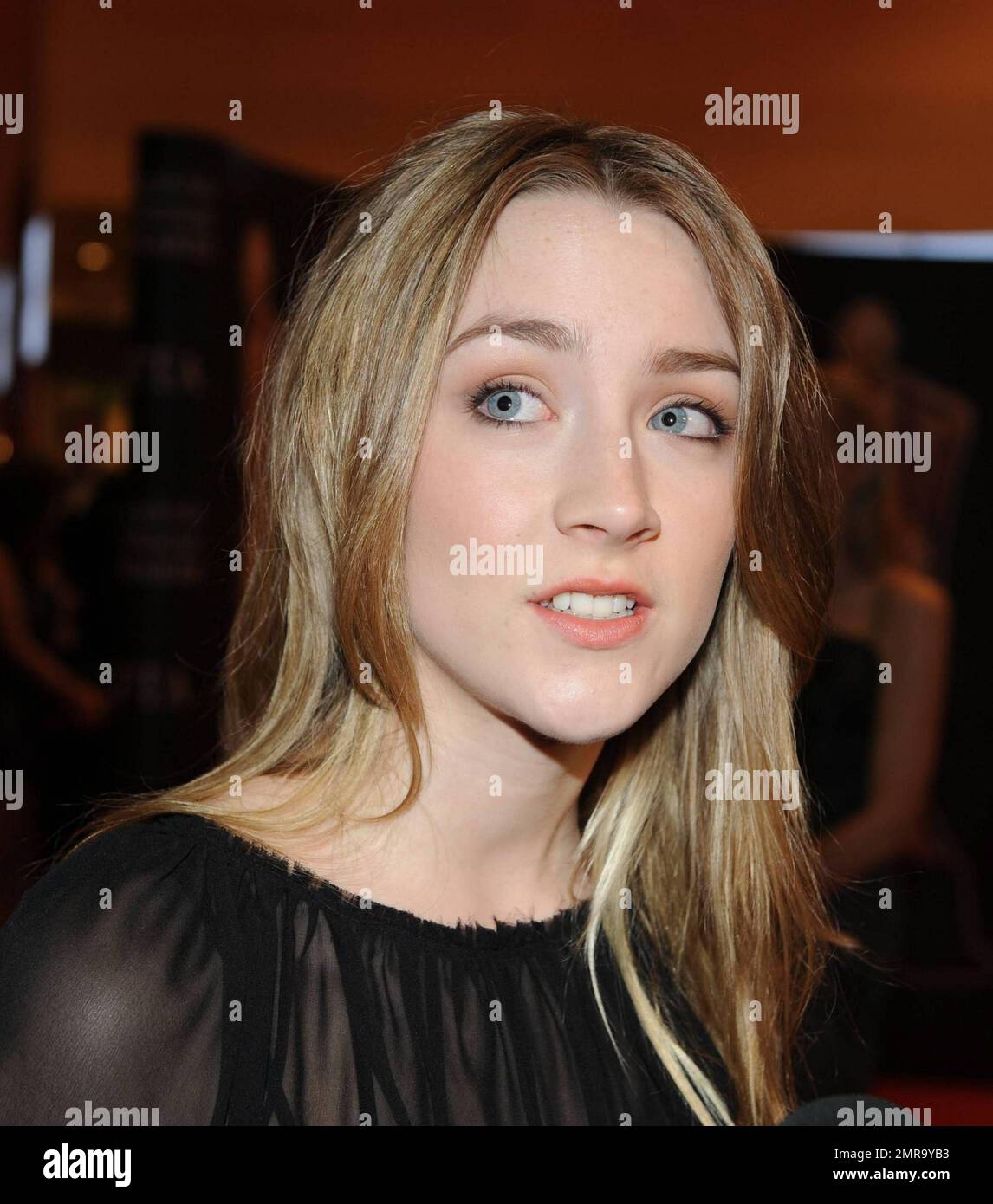 Elegant yet still a feisty teen, actress Saoirse Ronan, 16, makes a funny  face and wears colorful bracelets with her sophisticated black gown on the  red carpet at the 8th Annual Irish