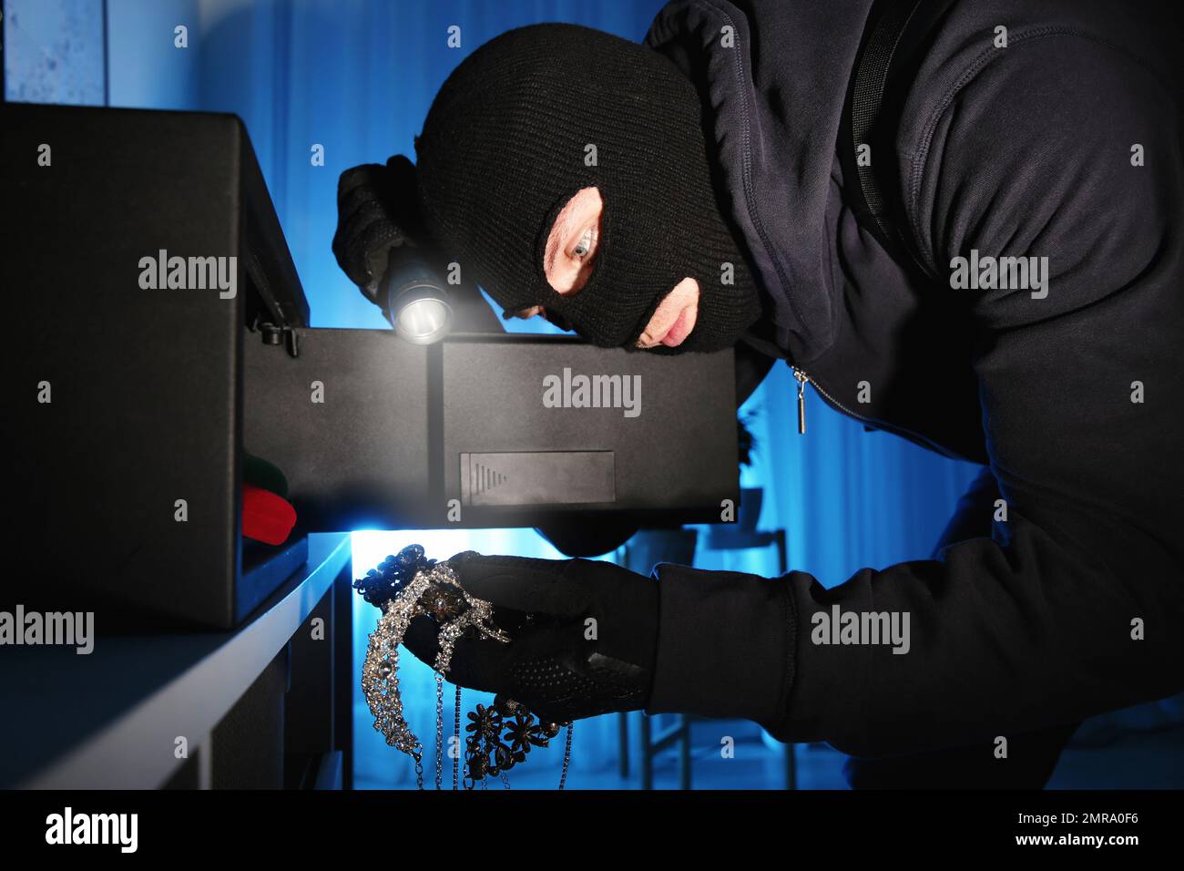 Thief taking jewelry out of steel safe indoors at night Stock Photo Alamy