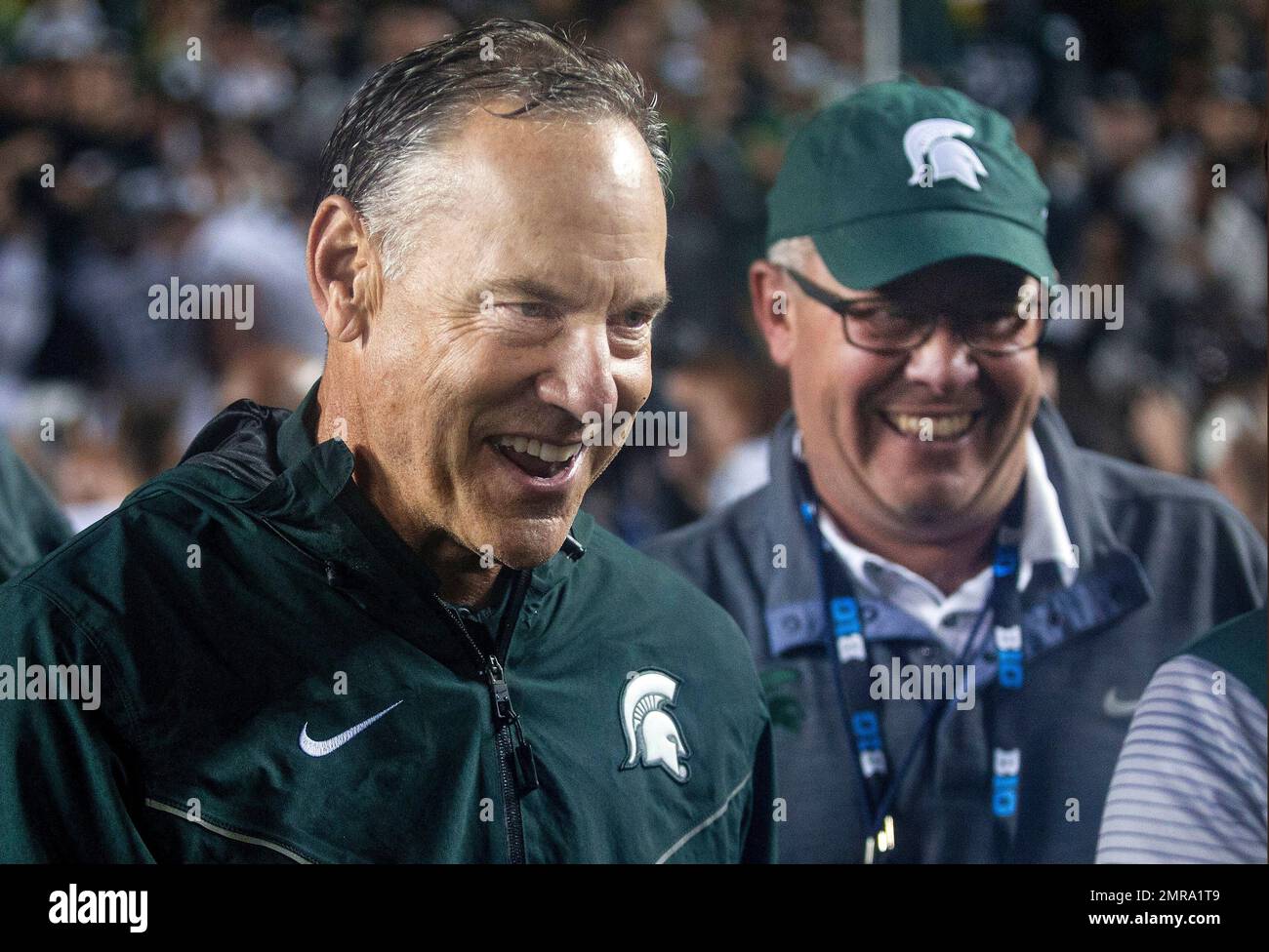 FILE - In this Saturday, Oct. 7, 2017, file photo, Michigan State head coach  Mark Dantonio, left, celebrates with athletic director Mark Hollis, right,  after the Spartans defeated Michigan 14-10 in an