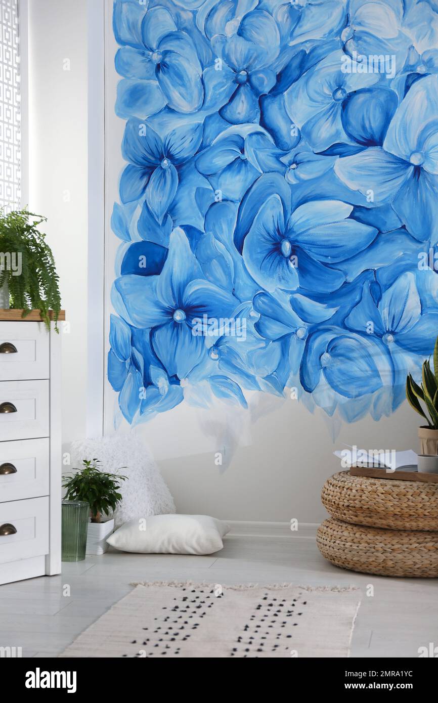 Stylish living room with blue flowers painted on wall. Floral pattern ...