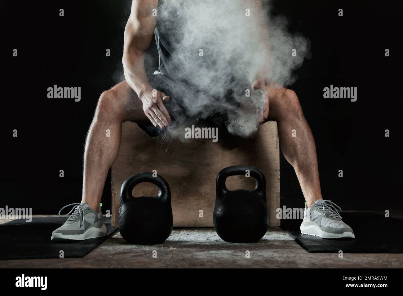Strong man applying magnesium powder on hands before training with