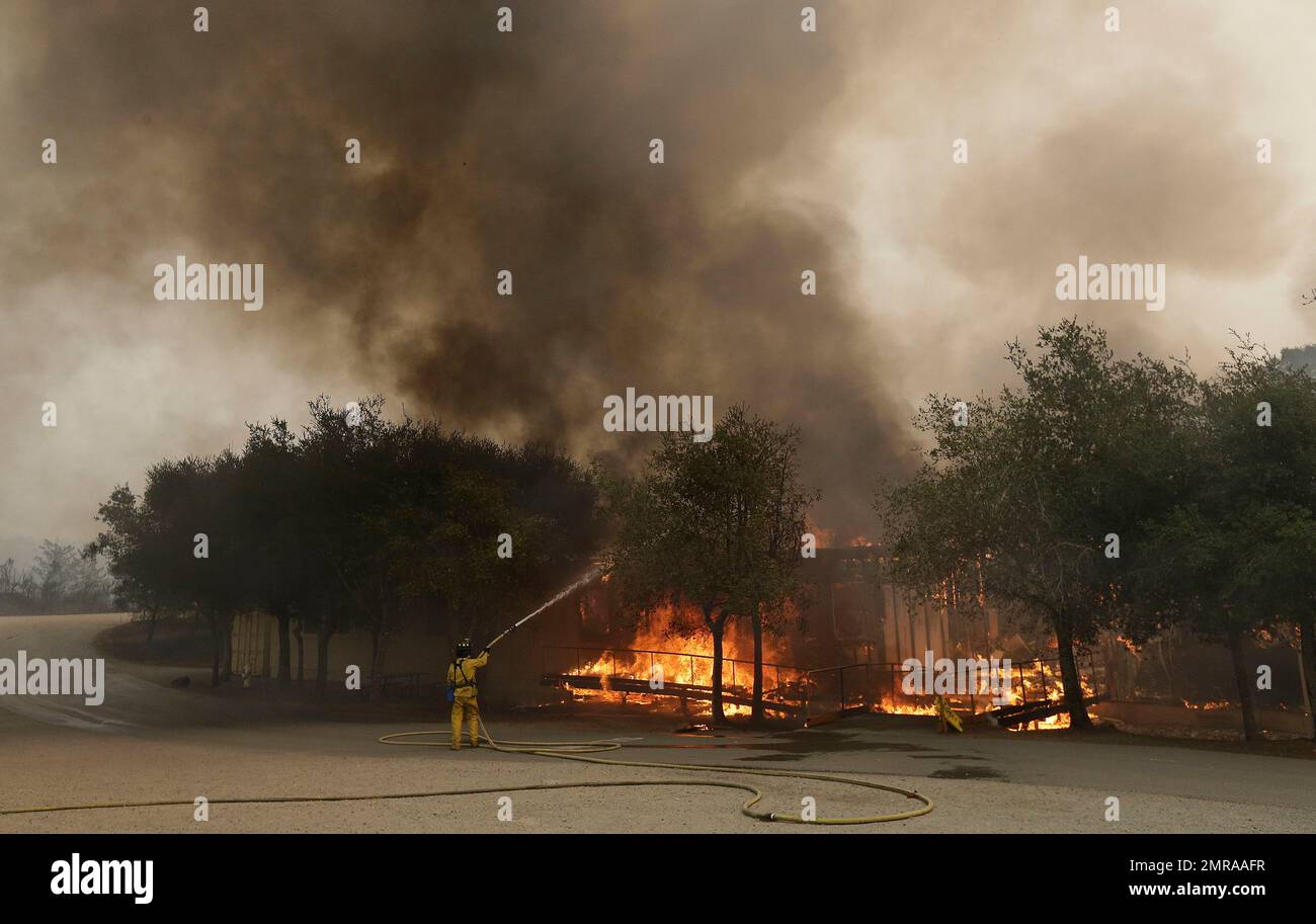 A firefighter sprays a Keysight Technologies building in Santa Rosa, Calif., Monday, Oct. 9