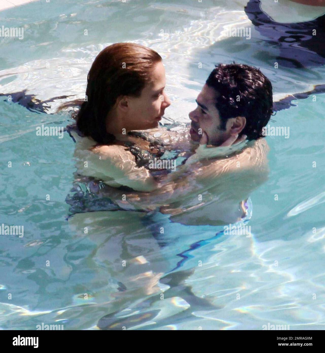 Exclusive!! French actor Jamel Debbouze and wife Melissa Theuriau kiss and cuddle in the pool at their exclusive Miami Beach hotel. Miami, FL 2/23/09 Stock Photo