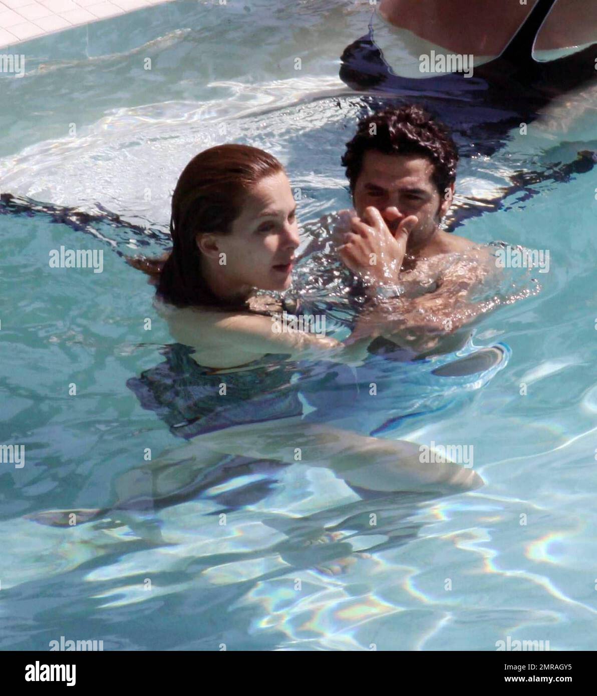 Exclusive!! French actor Jamel Debbouze and wife Melissa Theuriau kiss and cuddle in the pool at their exclusive Miami Beach hotel. Miami, FL 2/23/09 Stock Photo
