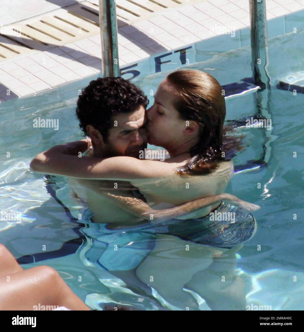 Exclusive!! French actor Jamel Debbouze and wife Melissa Theuriau kiss and cuddle in the pool at their exclusive Miami Beach hotel. Miami, FL 2/23/09 Stock Photo