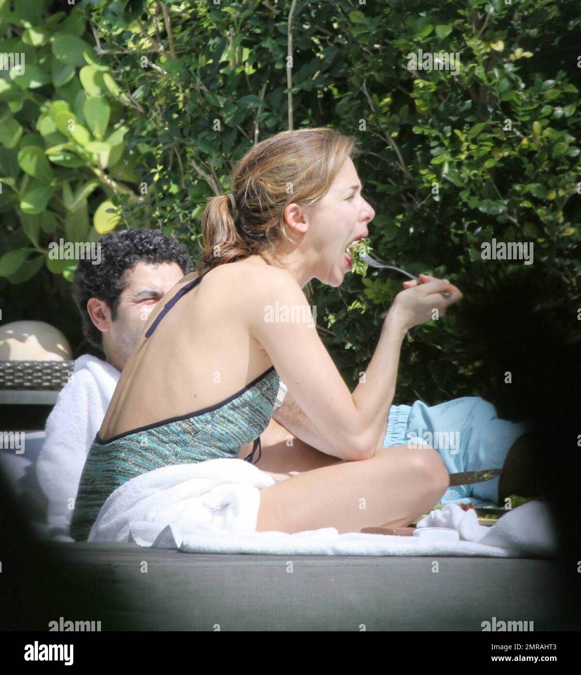 French actor Jamel Debbouze and wife Melissa Theuriau enjoy a day in the sun wearing bathing suits at their exclusive Miami Beach hotel pool.  The couple had lunch and were very intimate together, kissing and cuddling in front of hotel guests. Miami Beach, Florida. 2/23/09 Stock Photo