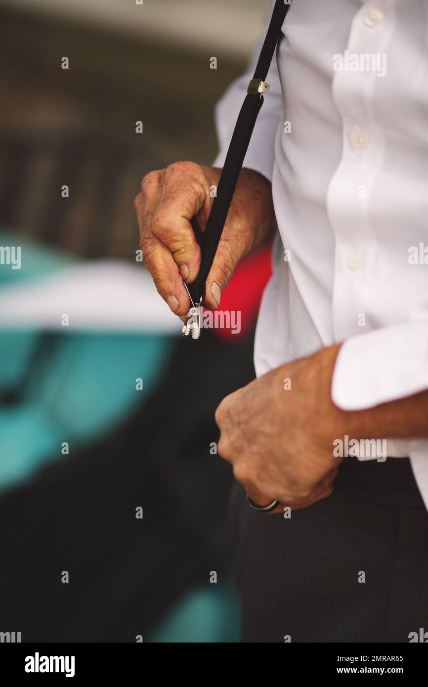 A man fixing a suspender on pants Stock Photo