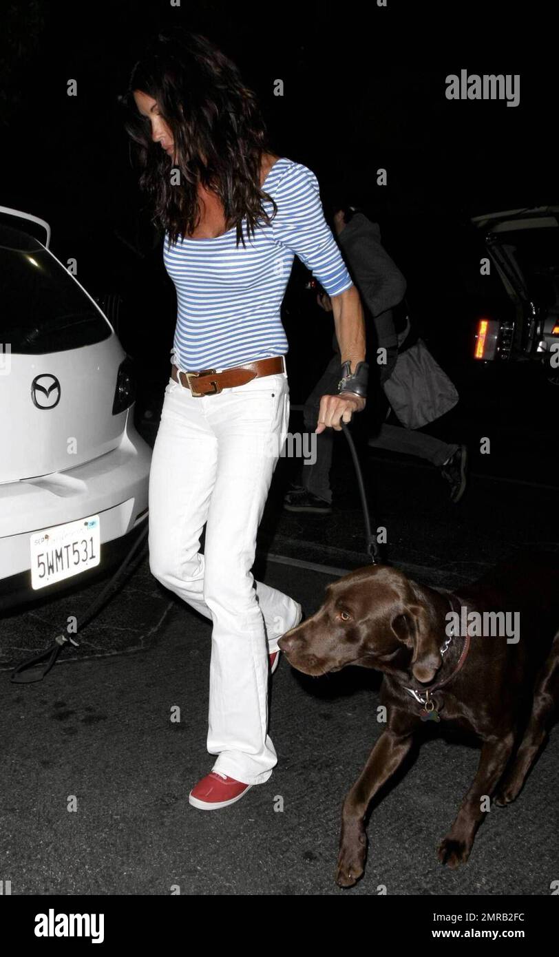 Fresh off her stint on 'I'm a Celebrity Get Me Out of Here,' Janice Dickinson and a friend end a day at the Malibu Country Mart, stopping for her dog to take care of business before loading him in the car and heading off. She looks tired as she playfully gives the finger to photographers while leaving. Malibu, CA. 7/5/09.      . Stock Photo