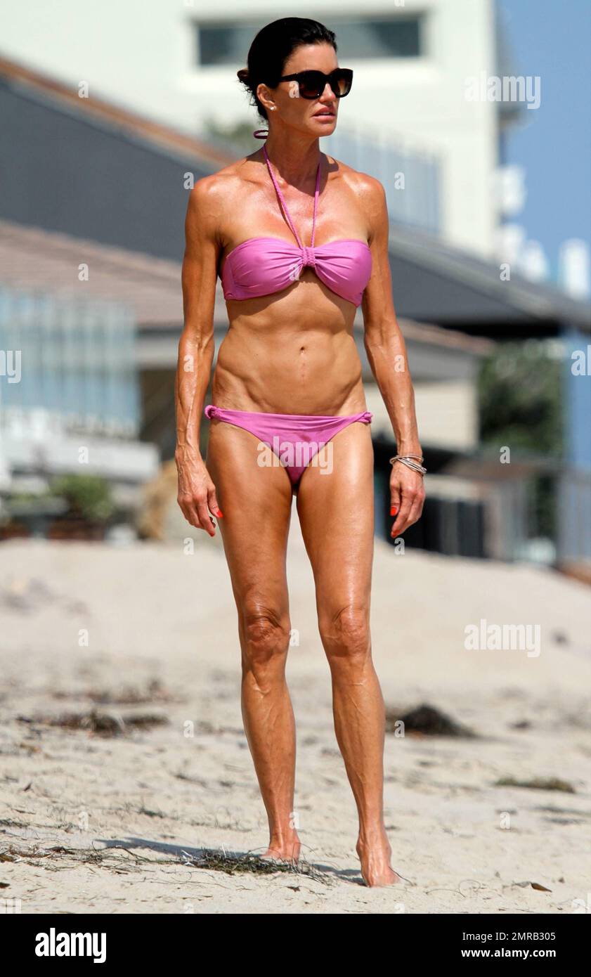 Janice Dickinson shows off her amazing figure in a blink bikini as she  takes a stroll on Malibu Beach. The 57 year old former supermodel was seen  tossing a football as she