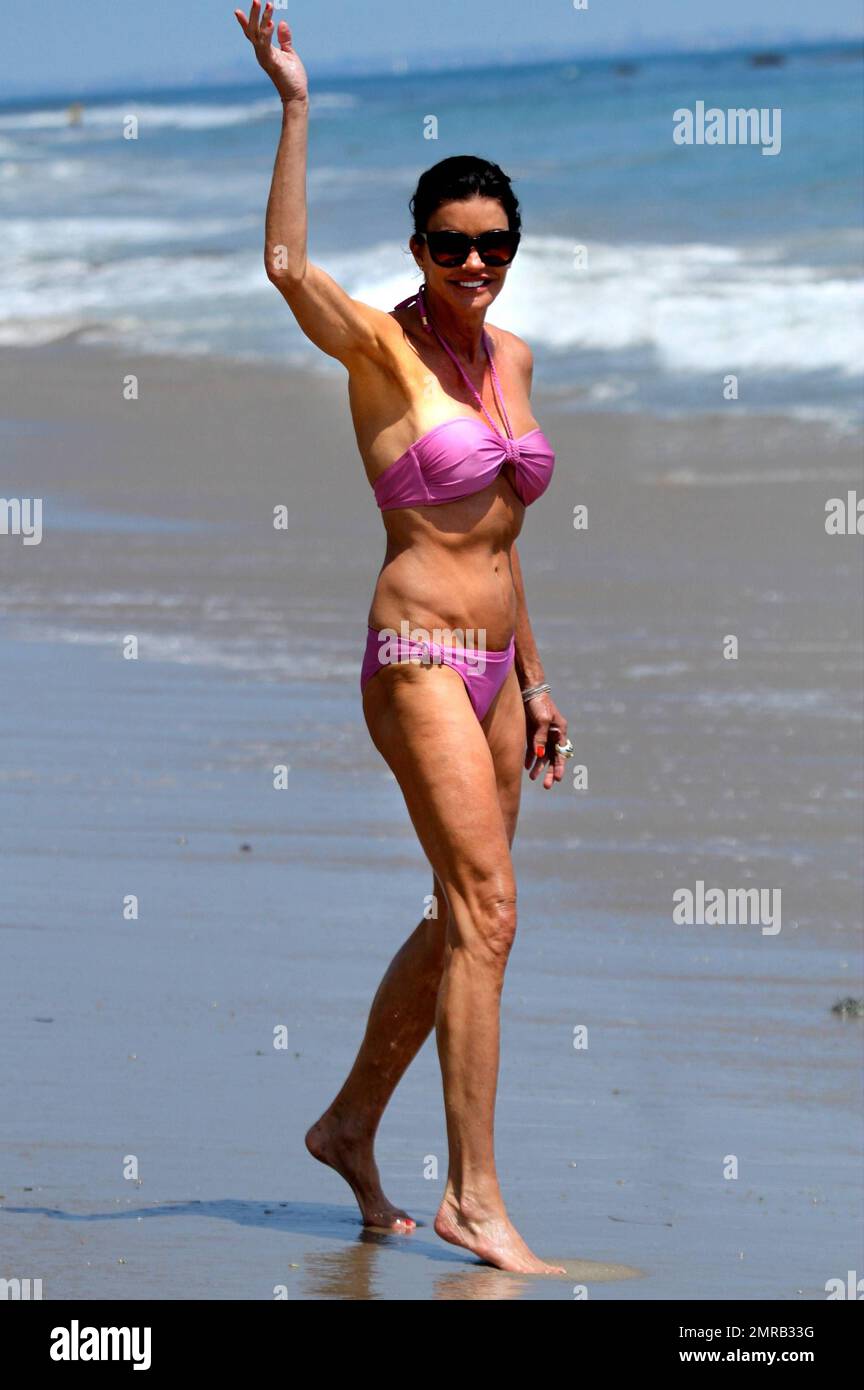 Janice Dickinson shows off her amazing figure in a blink bikini as she  takes a stroll on Malibu Beach. The 57 year old former supermodel was seen  tossing a football as she