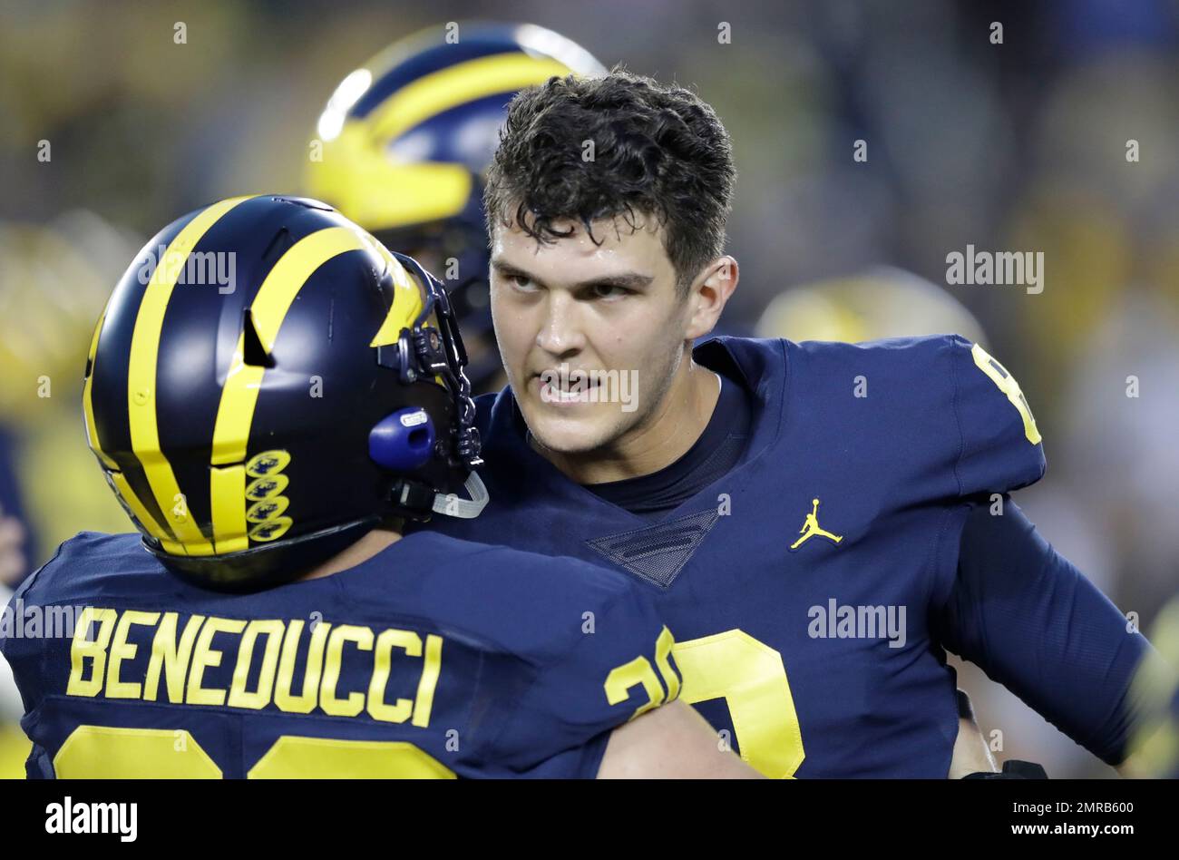 Michigan quarterback John O'Korn, right, hugs fullback Joe Beneducci during warmups of an NCAA college football game against Michigan State, Saturday, Oct. 7, 2017, in Ann Arbor, Mich. (AP Photo/Carlos Osorio Stock