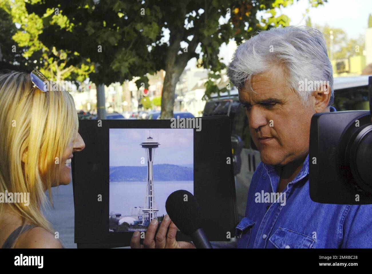 Jay Leno shows a passerby photos of some of the world's most well known