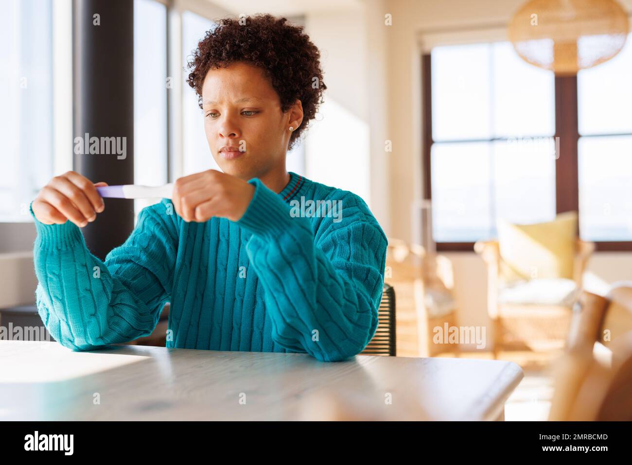 Worried african american woman looking at pregnancy test, with copy space Stock Photo