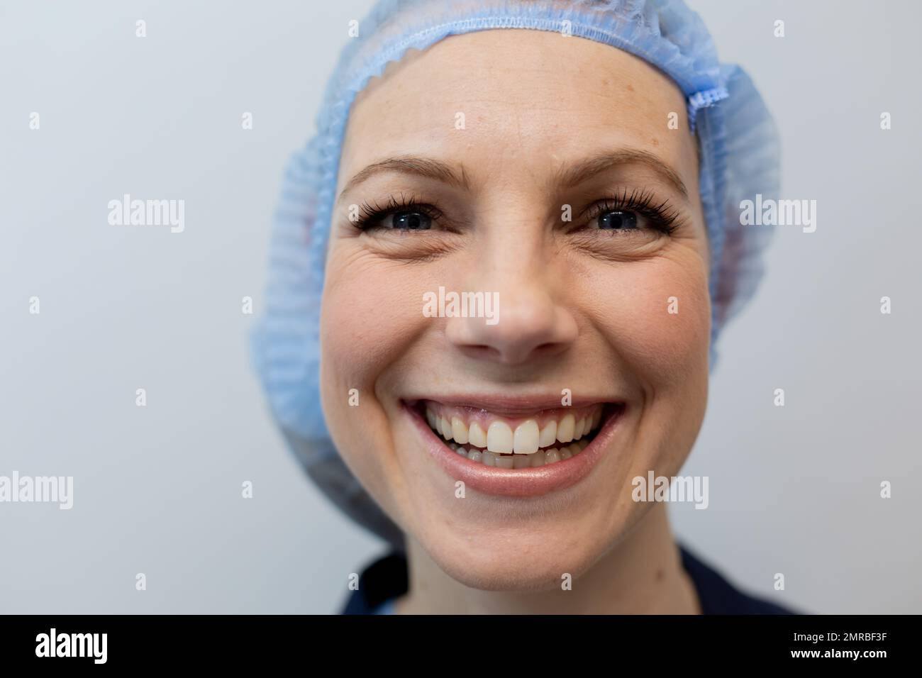 Portrait of happy caucasian female doctor wearing hair net working at