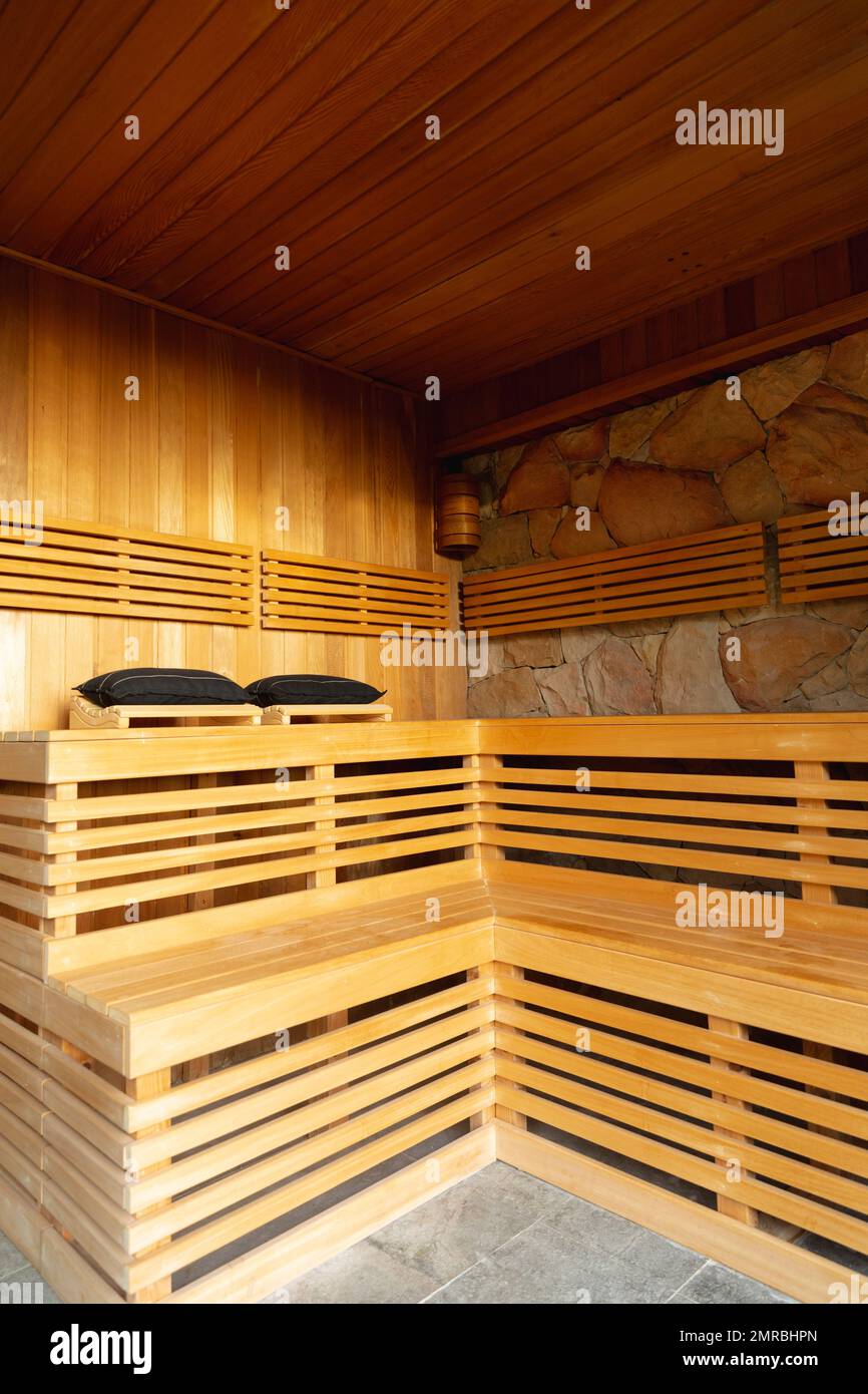 Vertical of wooden benches in sauna room at health spa, copy space Stock Photo