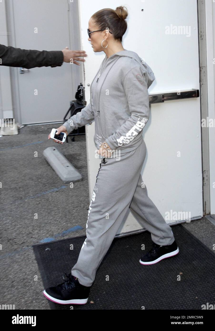 EXCLUSIVE Wearing black sneakers and a grey hoodie and sweat pants marked with a cross and the text I am Blessed 42 year old Jennifer Lopez is surrounded by bodyguards while shopping at Gucci