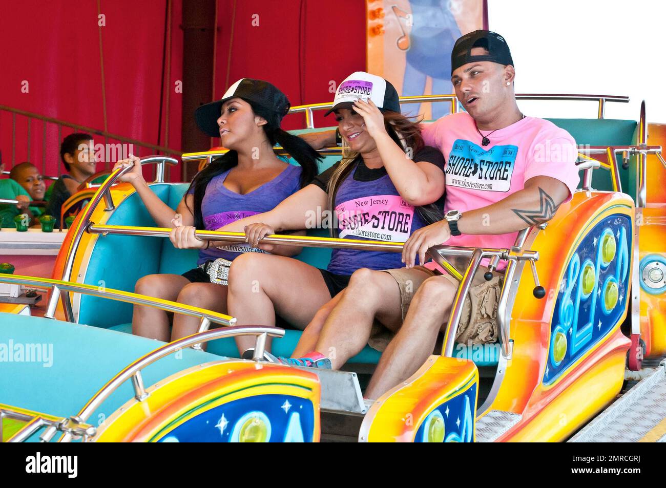 Nicole 'Snooki' Polizzi, Deena Cortese and DJ Pauly D (Paul Delvecchio) take a break from working at the Shore Store to ride a carnival ride while filming episodes for the MTV show 'Jersey Shore.' Seaside Heights, NJ. 7/7/11. Stock Photo