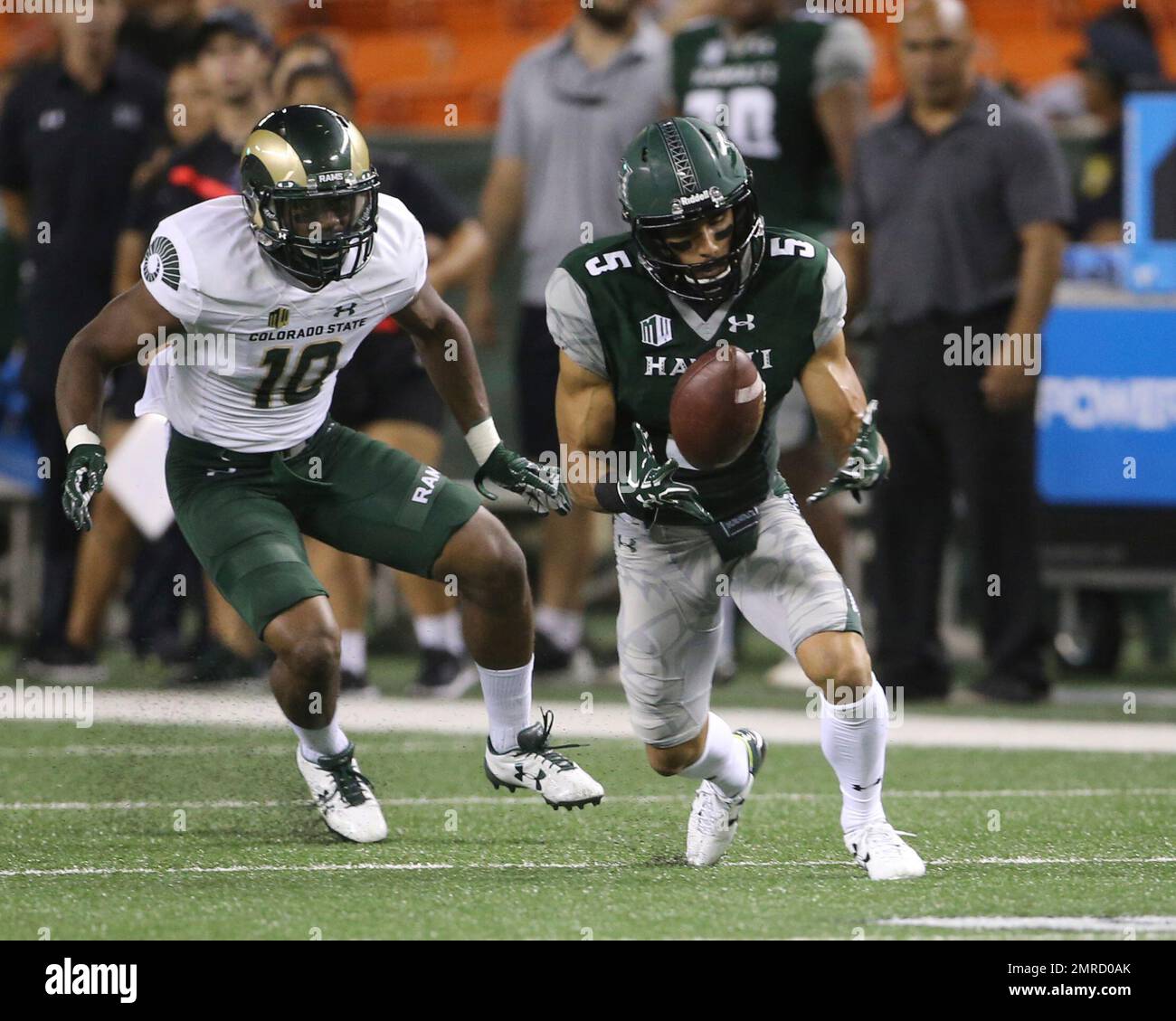 Hawaii wide receiver John Ursua (5), front, is dragged down by Colorado  State cornerback Anthony Hawkins after catching a pass for a touchdown in  the first half of an NCAA college football