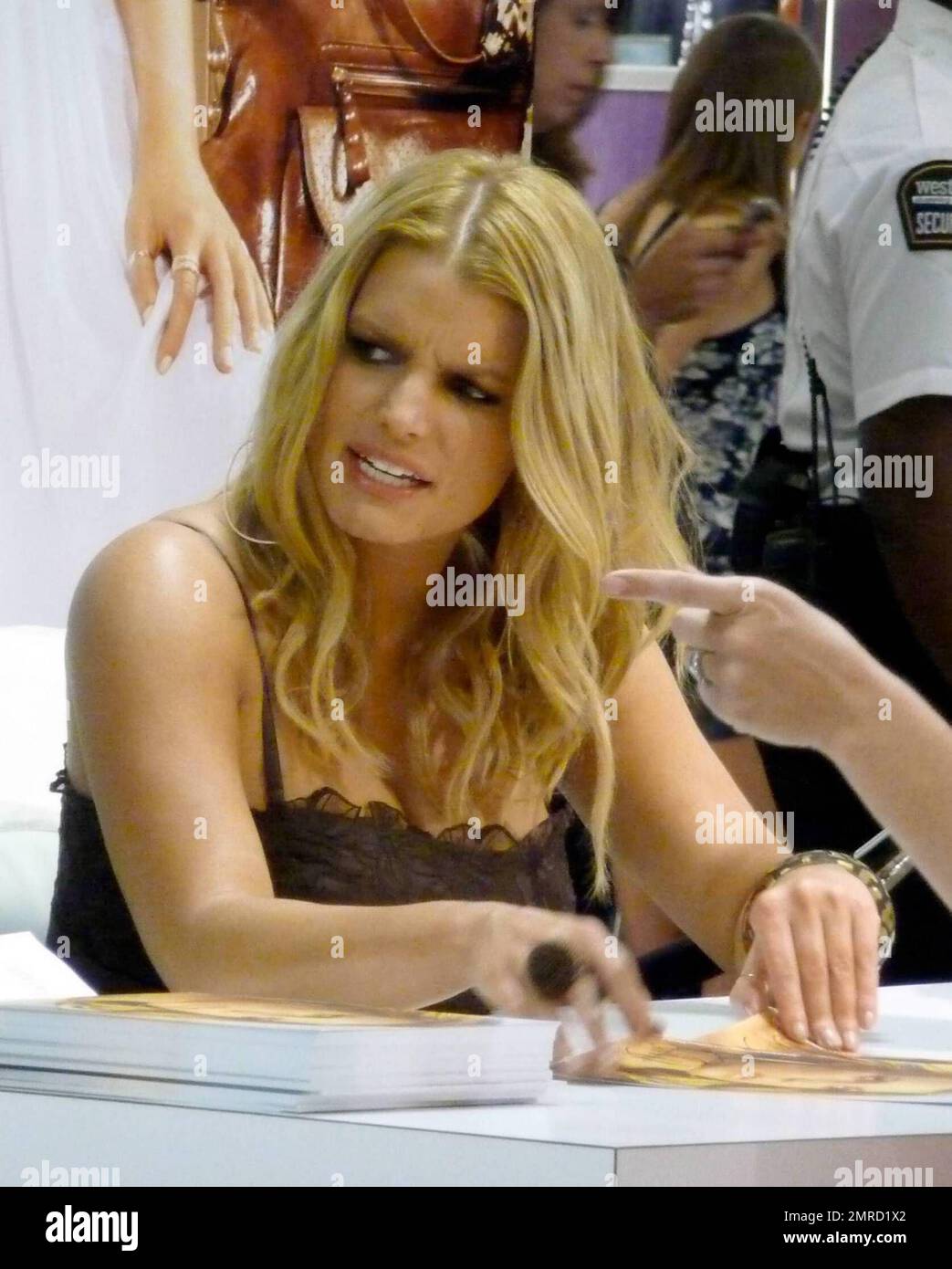 Singer and entrepreneur Jessica Simpson signs autographs for fans at a  Dilliards department store. During the session, Jessica looked beautiful in  a black dress and spent some time with a dog who