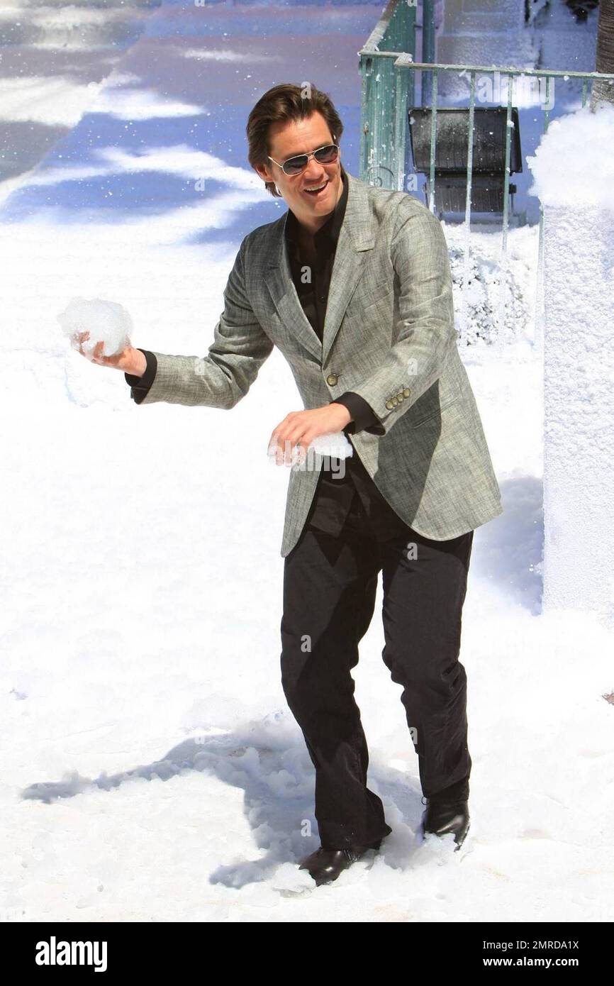 Jim Carrey playfully throws a snowball while attending the photocall