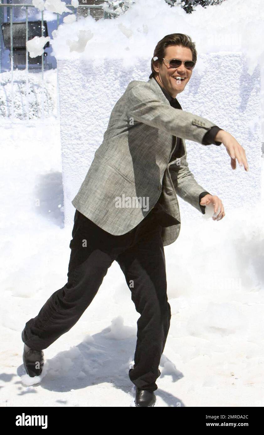 Jim Carrey playfully throws a snowball while attending the photocall