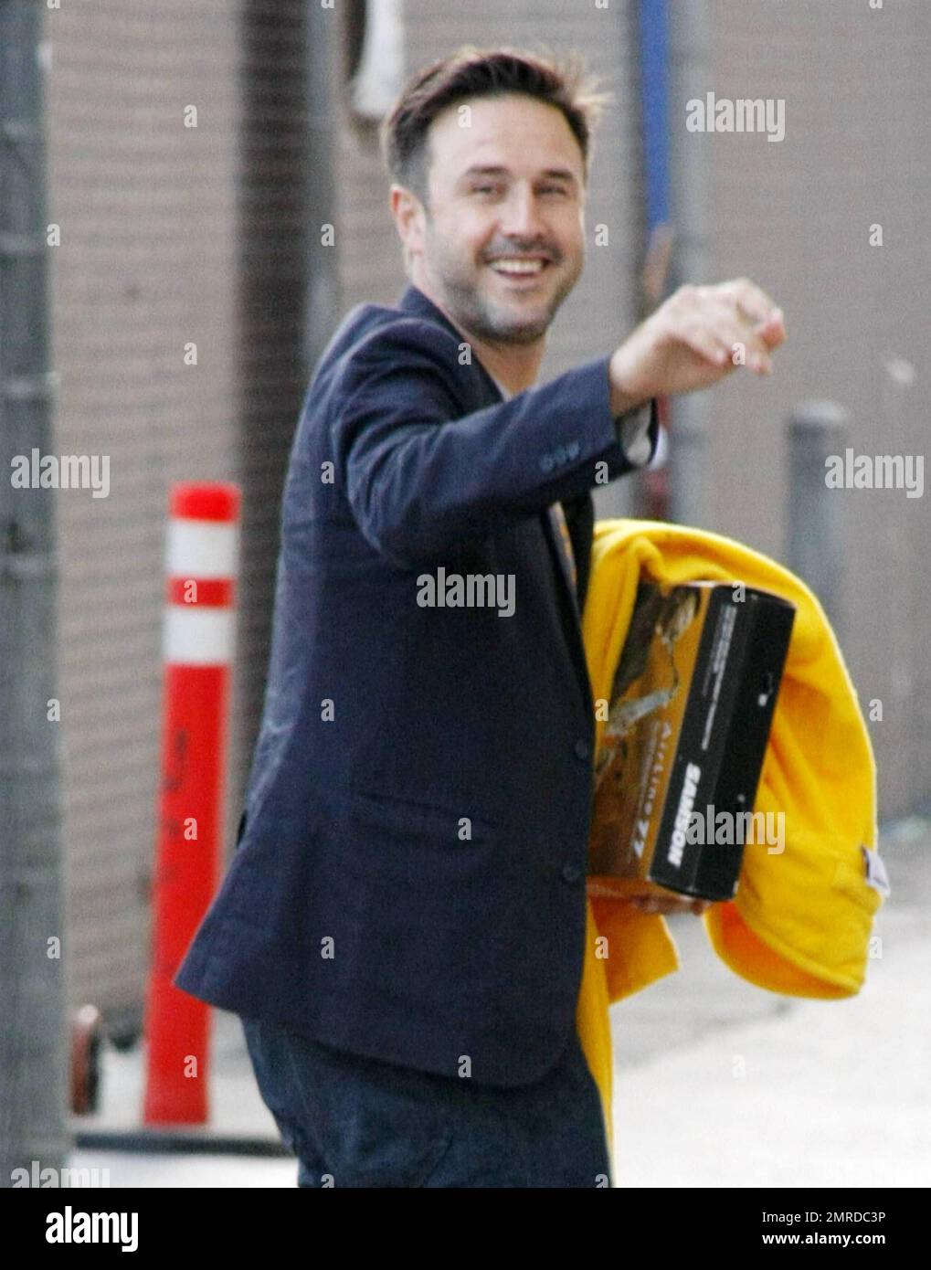 Actor and producer David Arquette gives the thumbs up and waves to waiting  fans as he arrives at the 