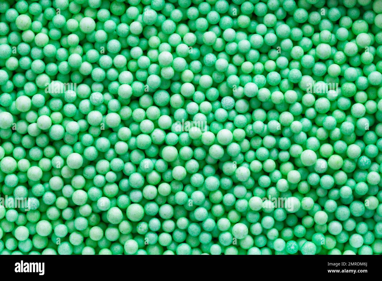 Small Green Polystyrene Balls in a Heap Background. Stock Photo
