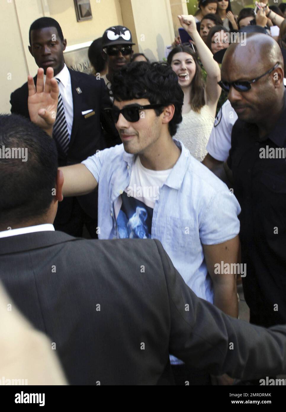 Singer Joe Jonas is presented with a birthday cake featuring an image of Daniel Craig during an