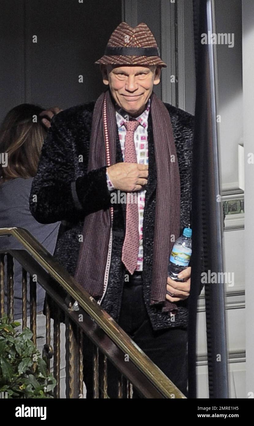 Actor John Malkovich smokes a cigarette while on the set of 
