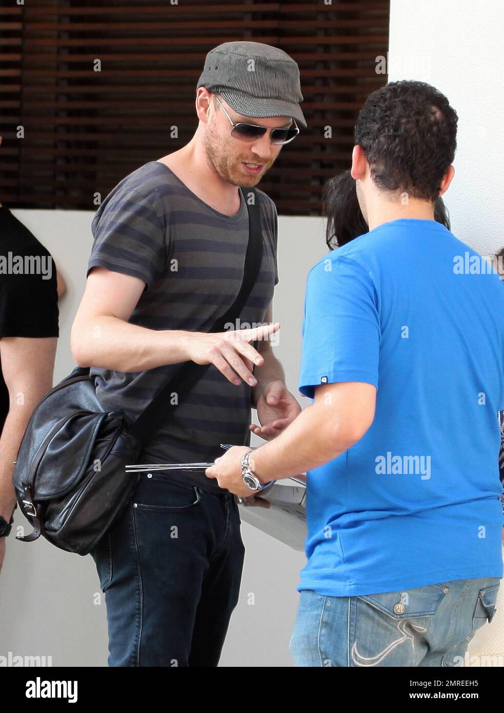 Coldplay co-founder Jonny Buckland signs autographs for fans before