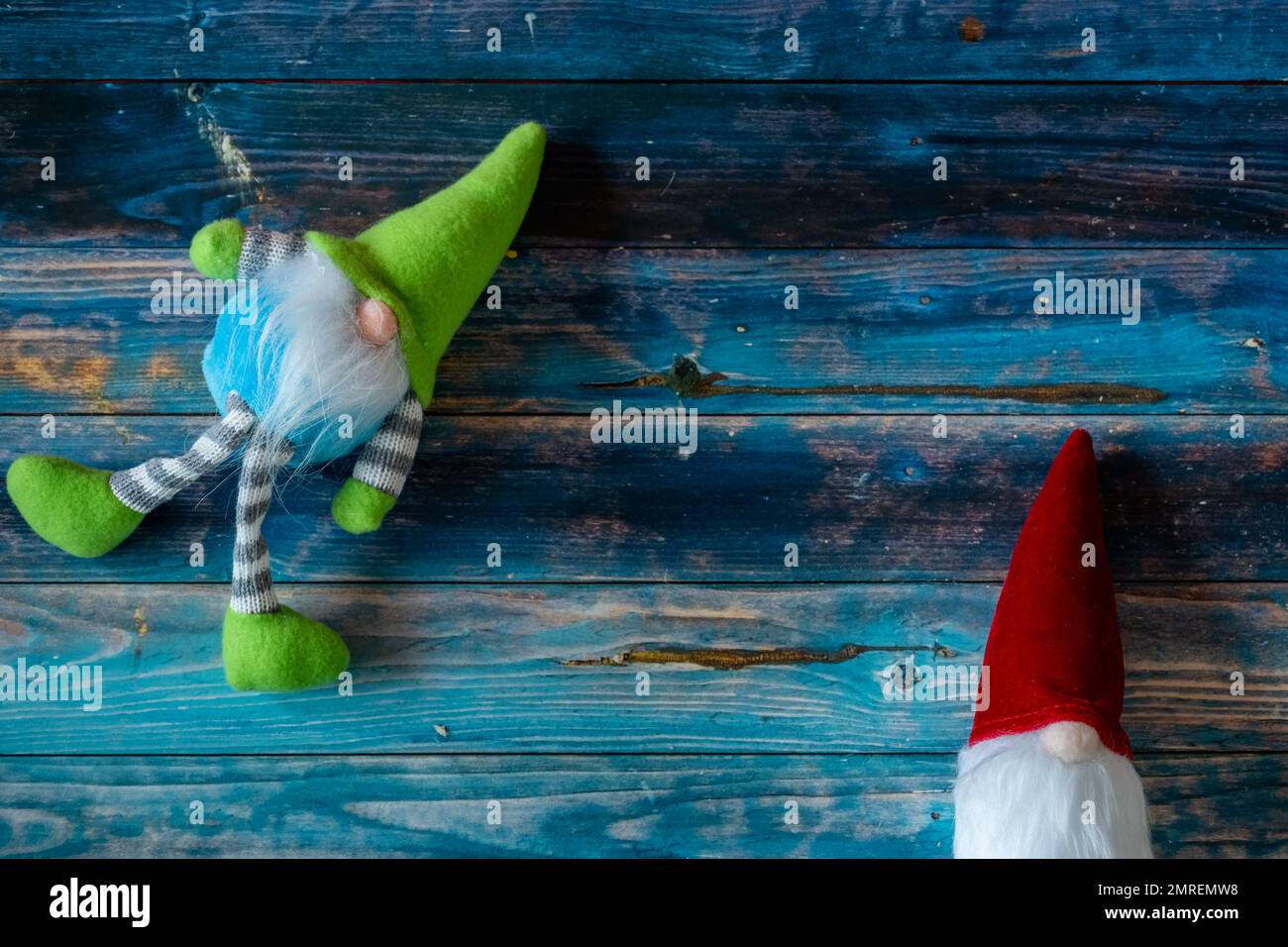 A top view of cute Christmas gnome toys on a blue wooden surface with copy space Stock Photo