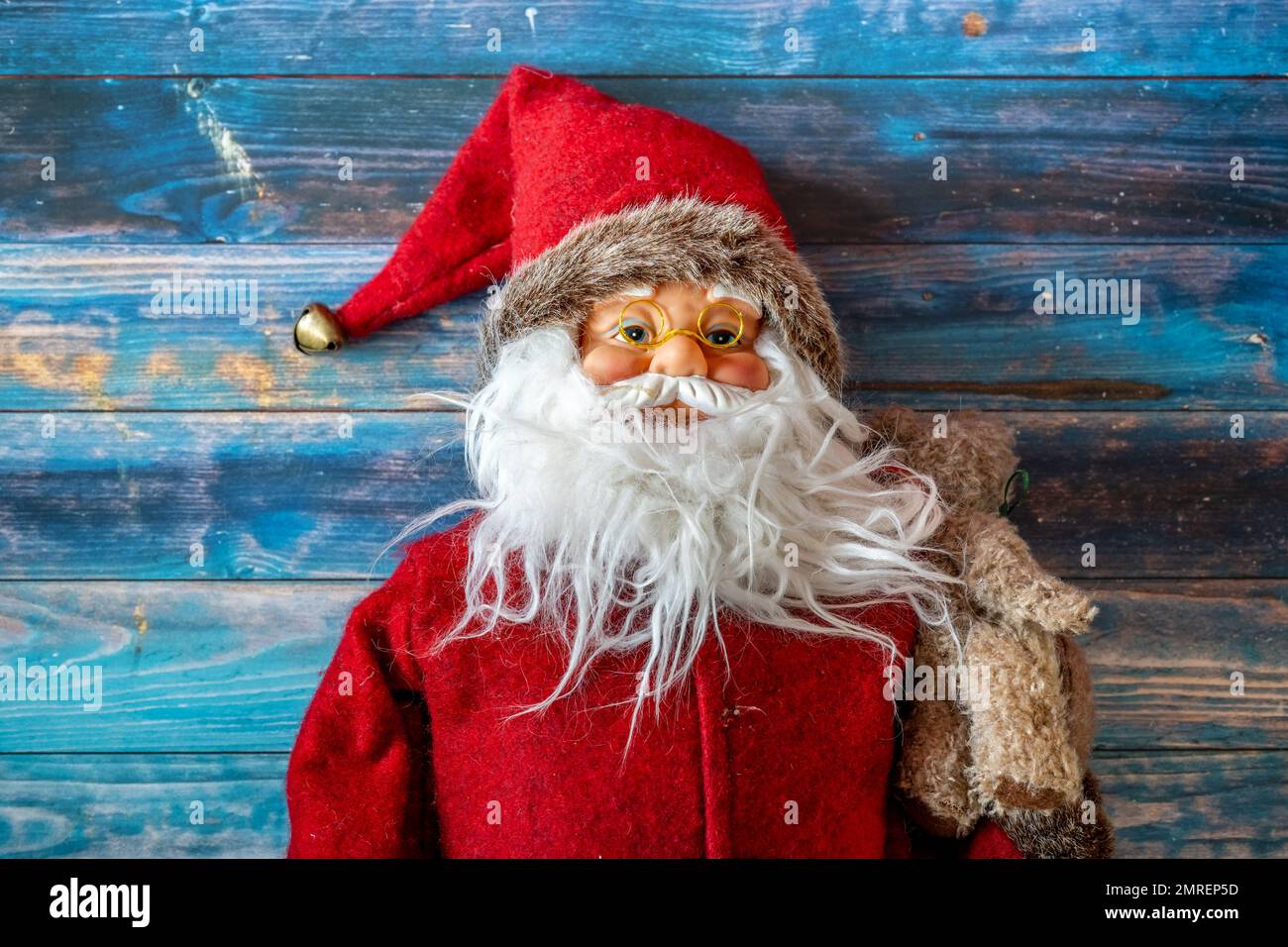 A top view of a cute Christmas Santa Claus toy on a blue wooden surface Stock Photo