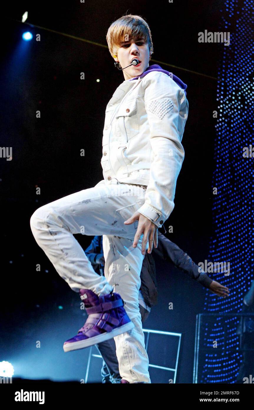 In a white buckle-detailed jacket, trendy paint splattered white jeans and  his trademark purple high top sneakers teen heartthrob Justin Bieber  performs live in concert at the American Airlines Arena. Bieber threw