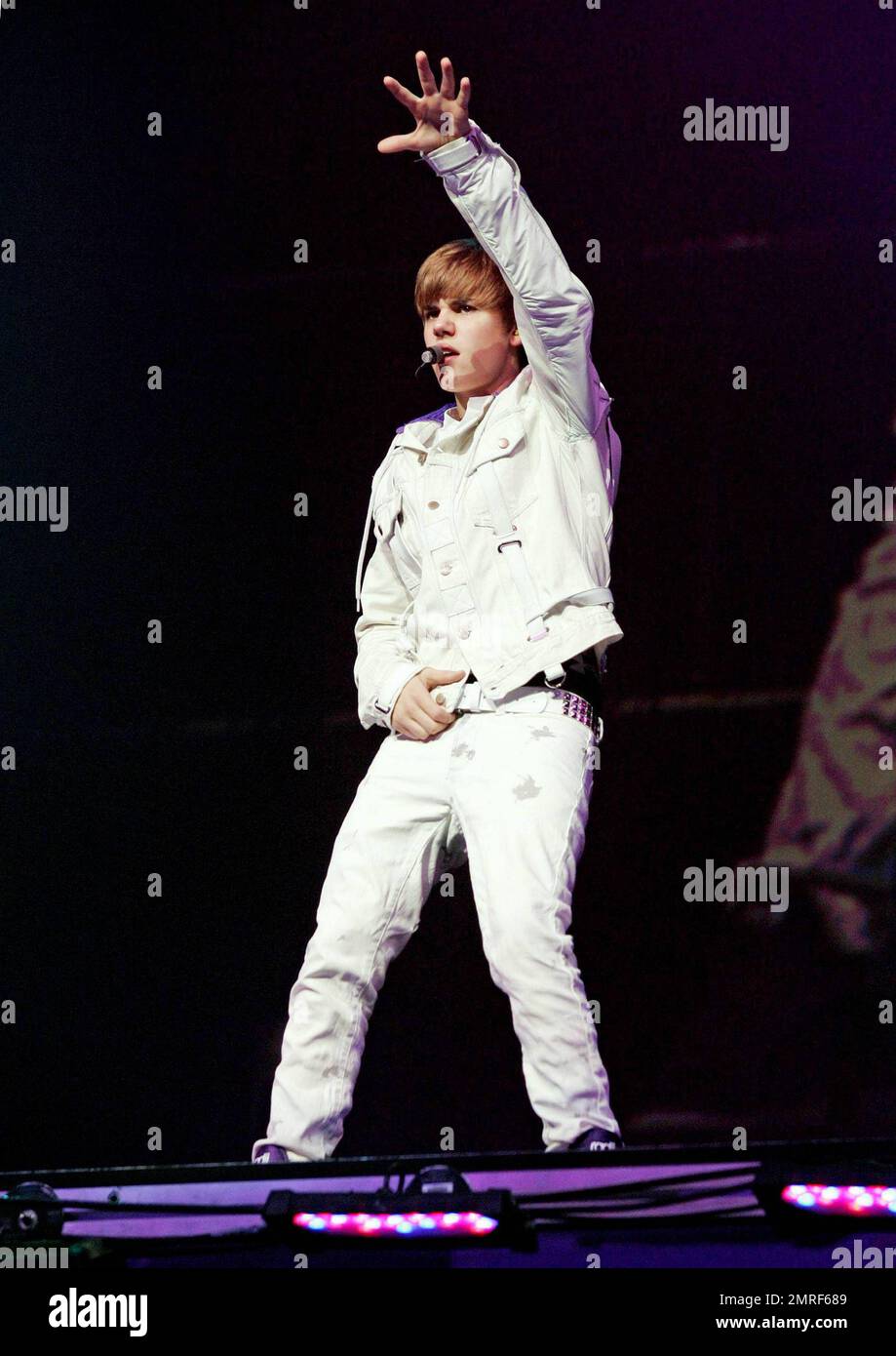 In a white buckle-detailed jacket, trendy paint splattered white jeans and his trademark purple high top sneakers teen heartthrob Justin Bieber performs live in concert at the American Arena. Bieber threw