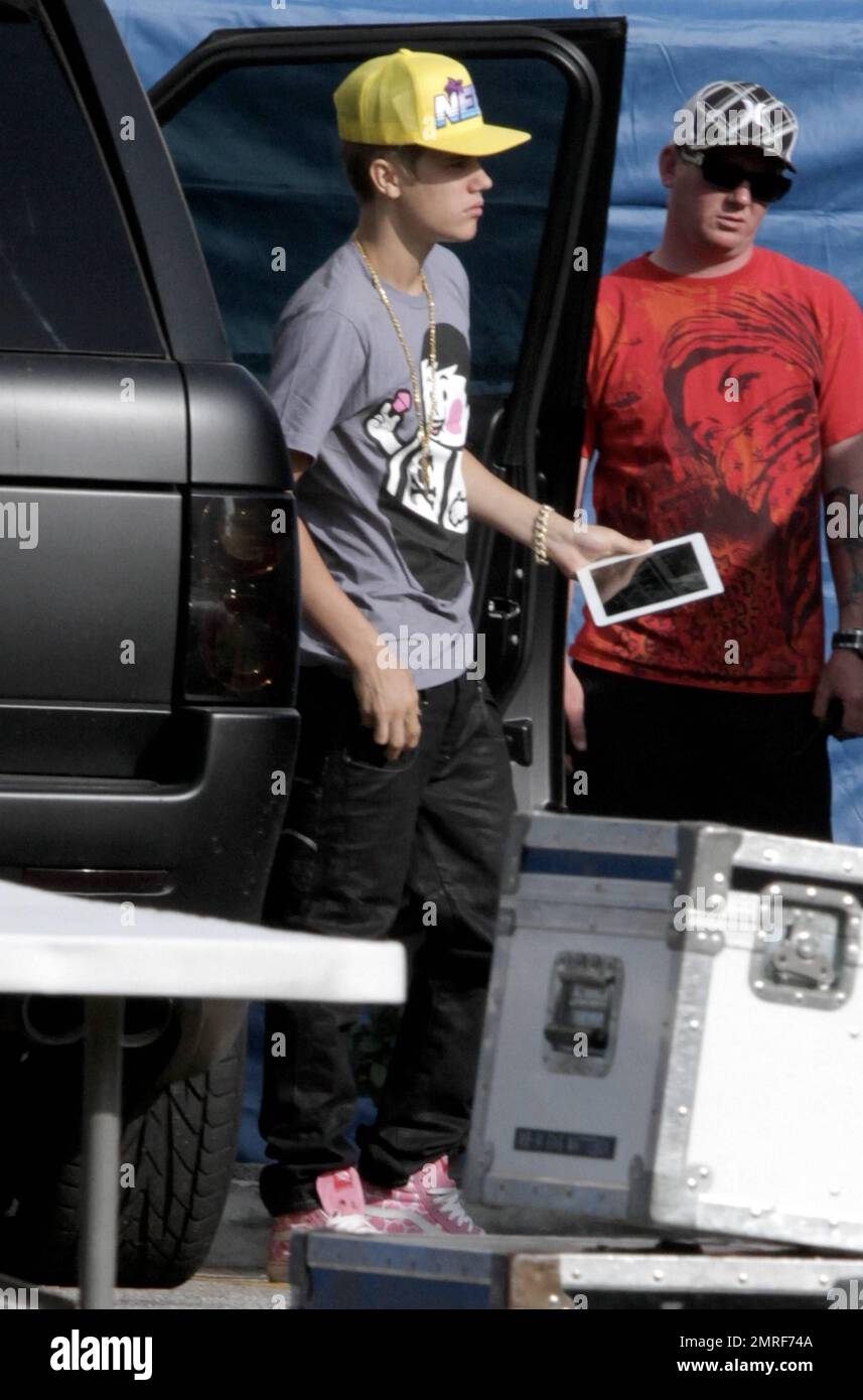 Teen pop superstar Justin Bieber carries an iPad as he arrives on the set  of his new video "Boyfriend" in downtown LA. Justin wore a grey t shirt,  yellow hat and pink