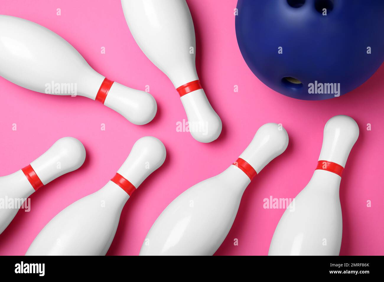 Bowling ball and pins on pink background, flat lay Stock Photo